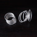Two silver rings on a dark wooden surface