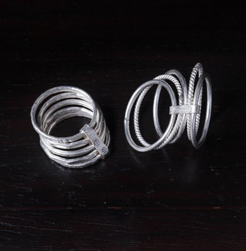 Two silver rings on a dark wooden surface