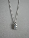 Silver necklace with a 'PEACE' pendant on a gray background