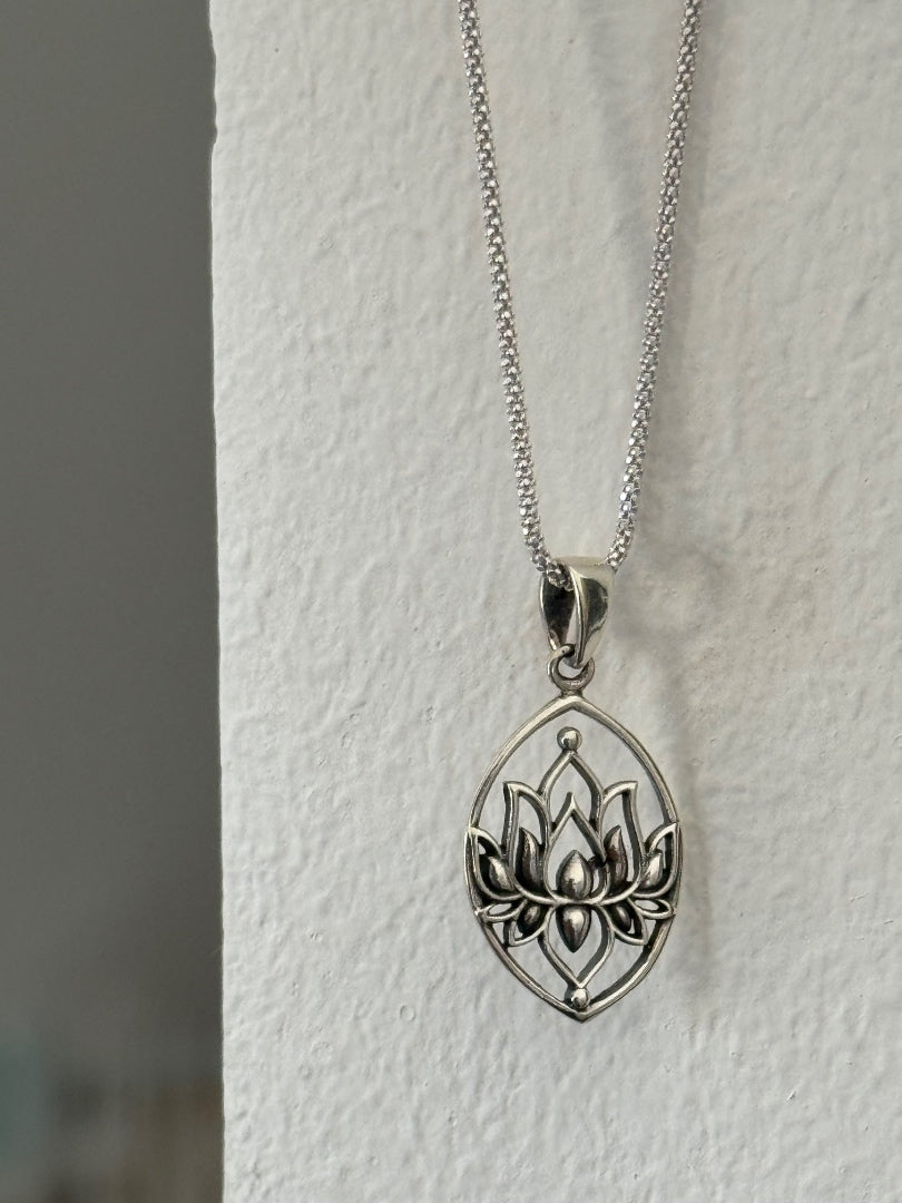 Silver lotus flower pendant necklace on a white background