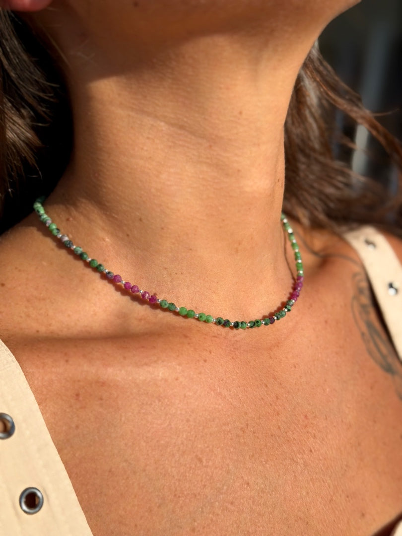 Close-up of a person wearing a colorful beaded necklace on a blurred background