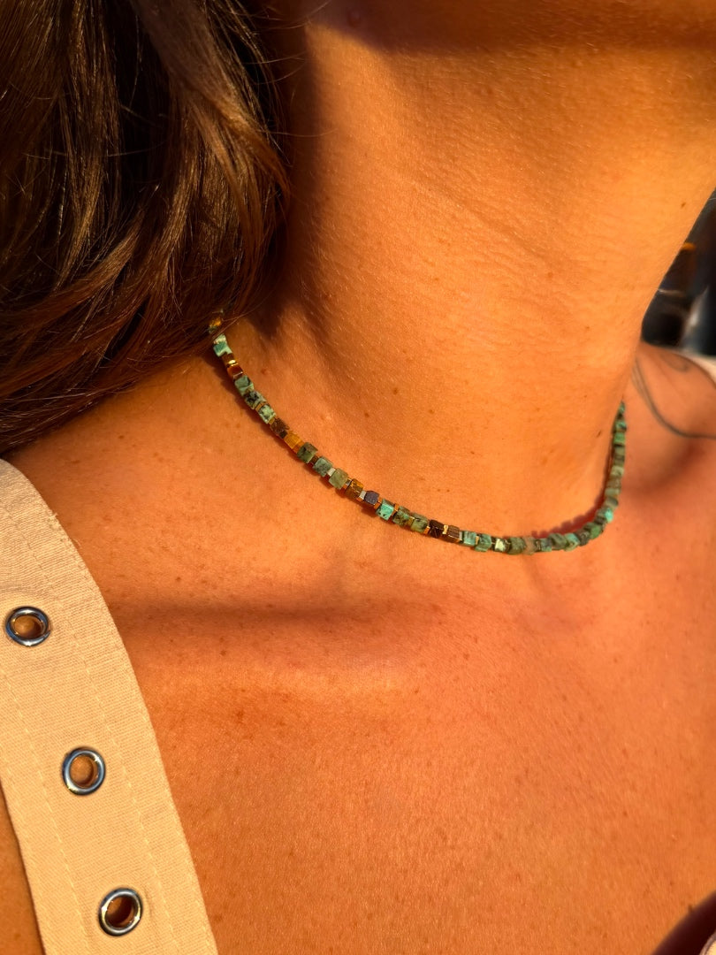 Necklace with green beads worn by a person, close-up on skin