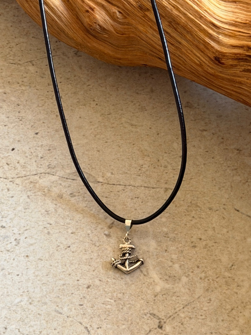 Necklace with a gold pendant on a beige surface