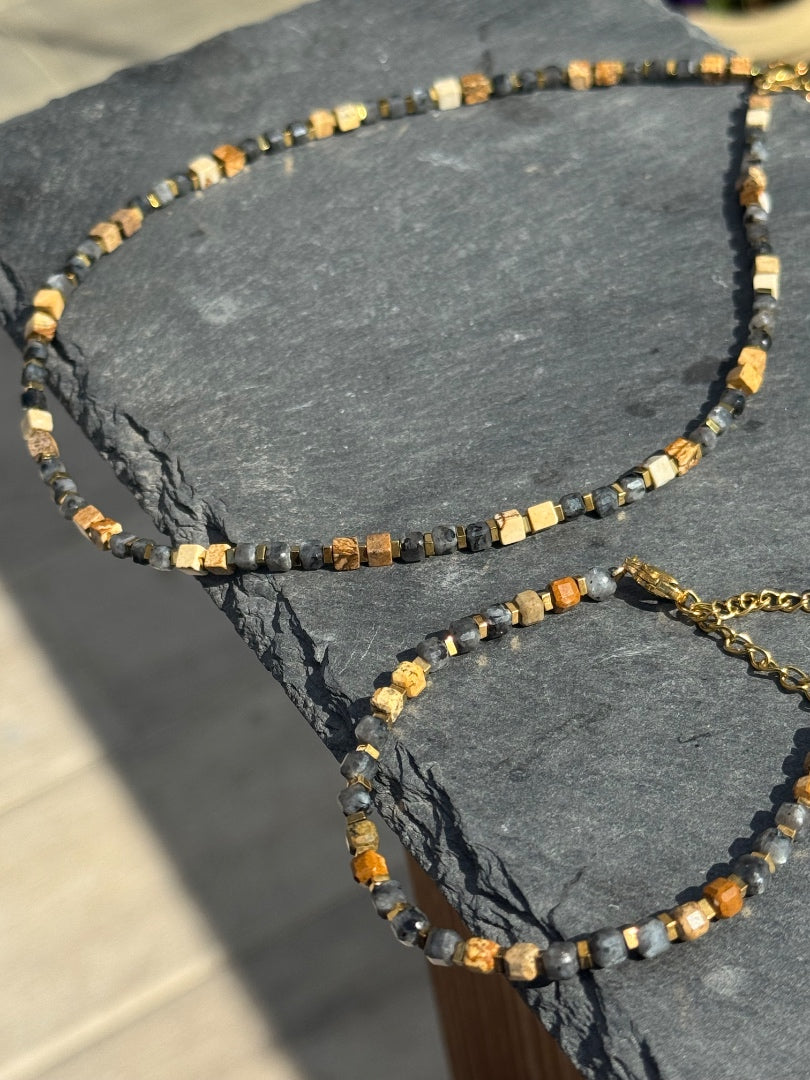 Necklace with beads and gold chain on a dark stone surface