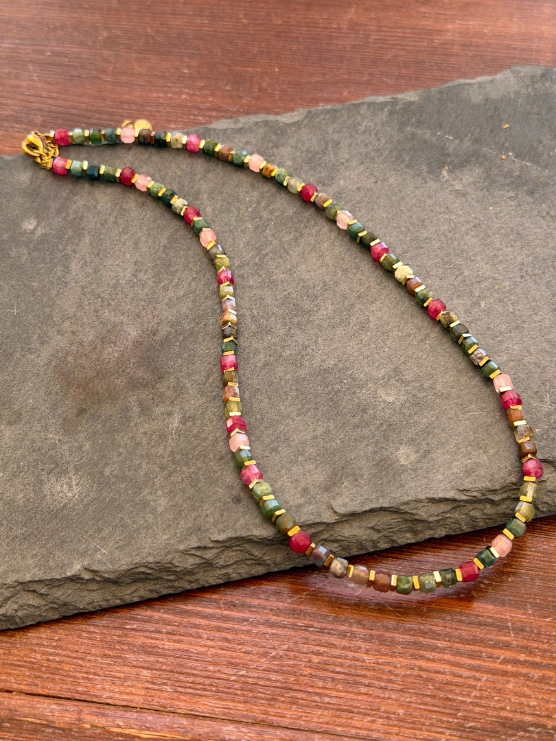 Multicolored beaded necklace on a dark stone surface