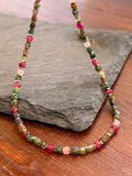 Multicolored beaded necklace on a stone surface