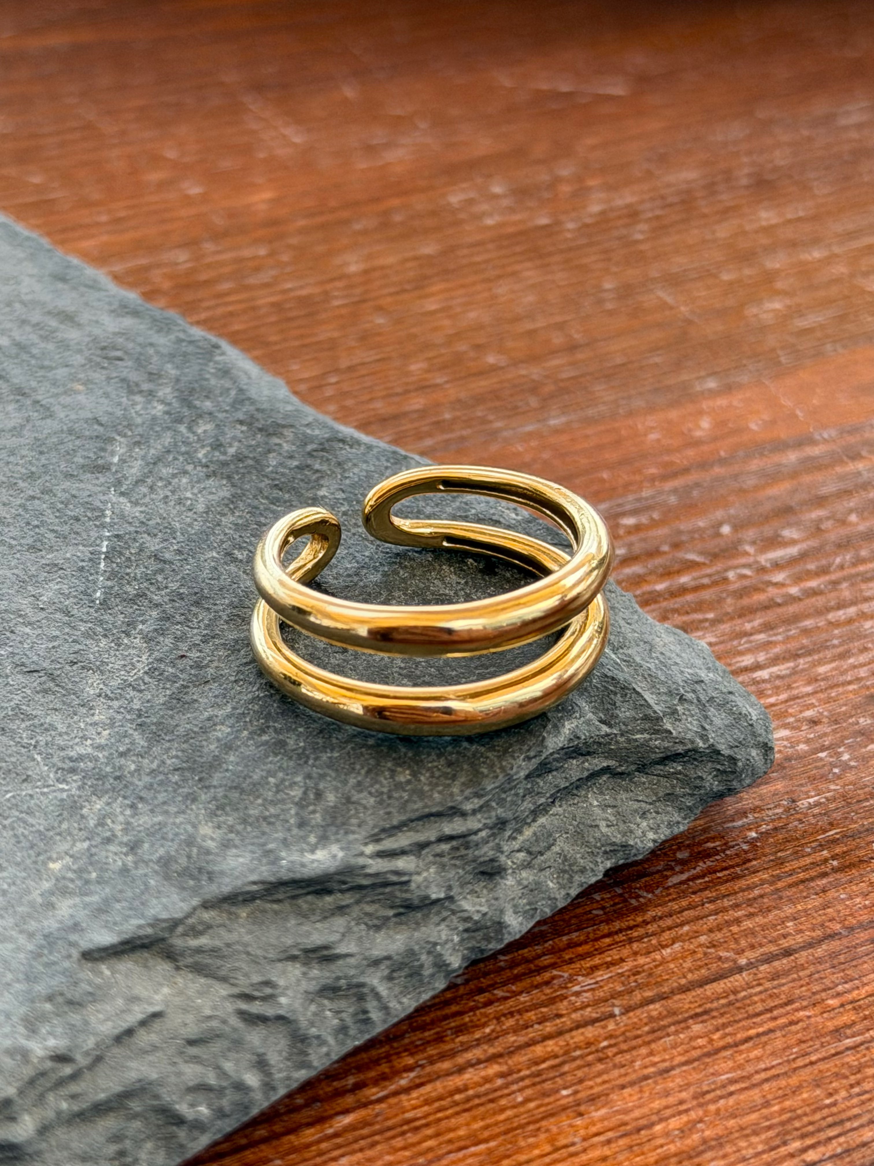 Gold ring on a stone surface with a wooden background