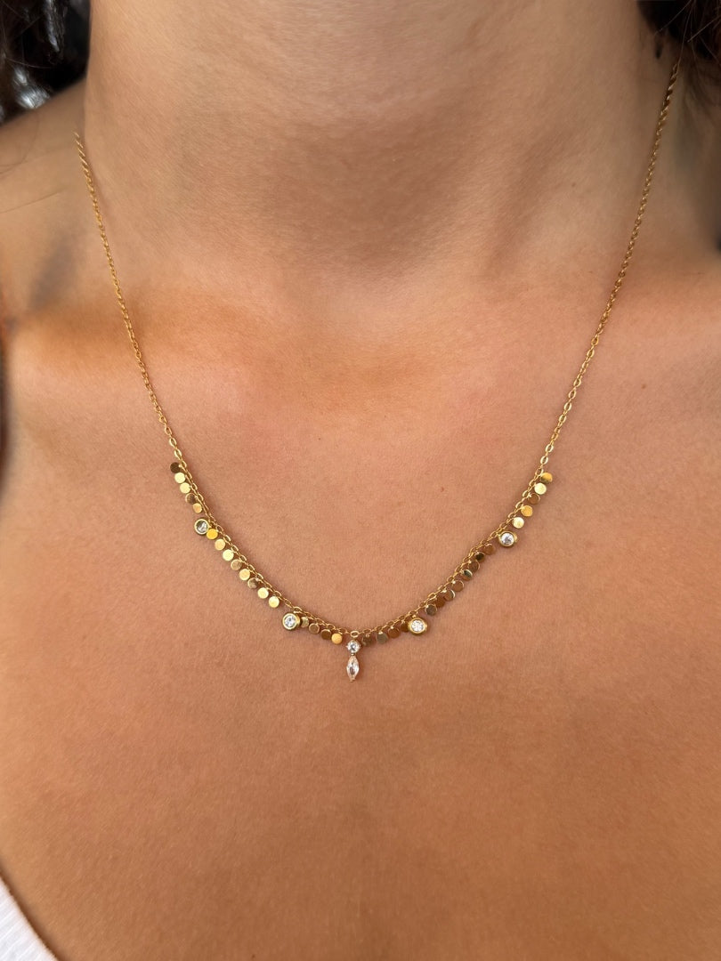 Gold necklace with small beads on a person's neck