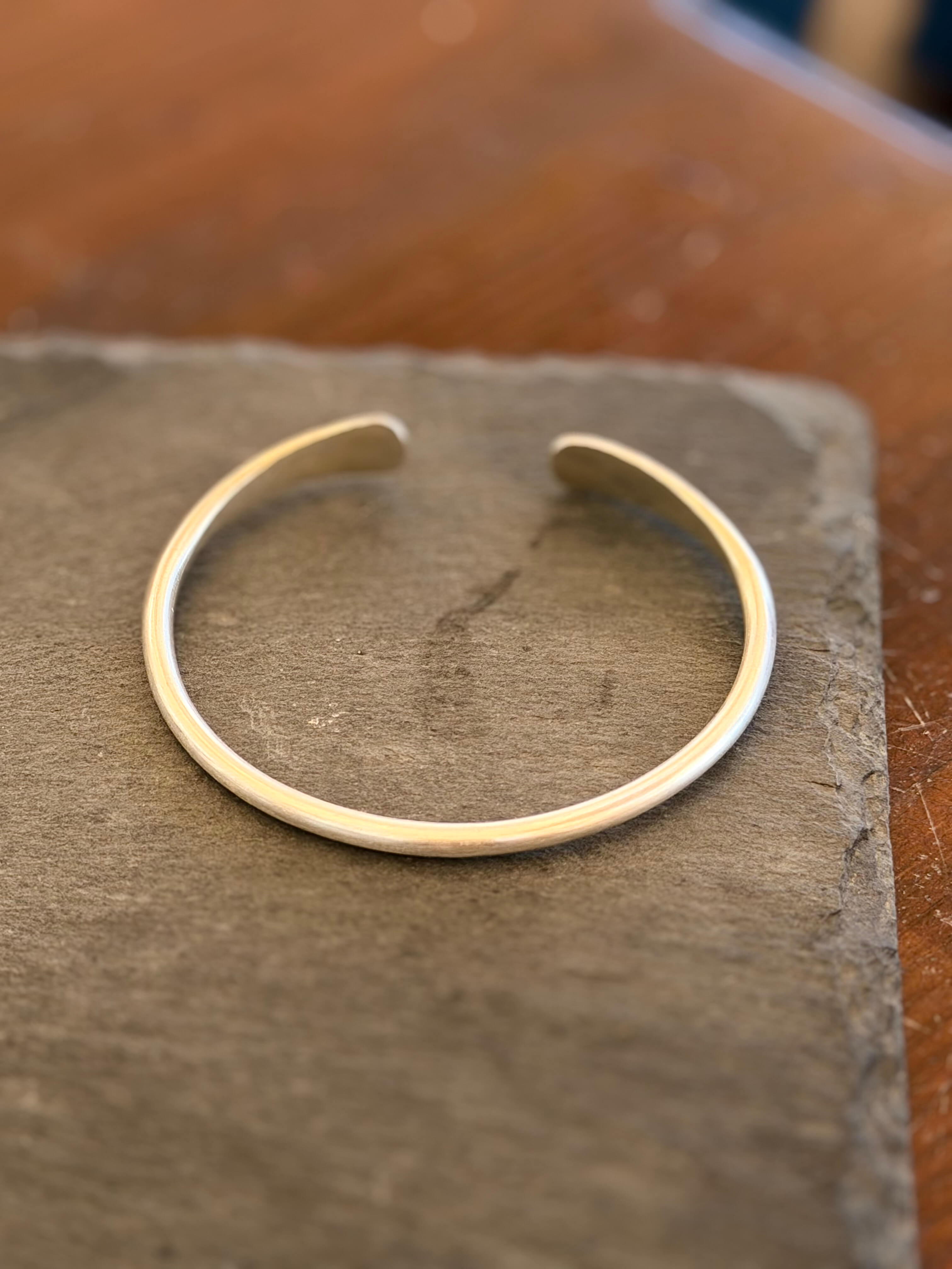 Silver bracelet on a textured stone surface