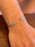 Silver bracelet on a wrist with a blurred background