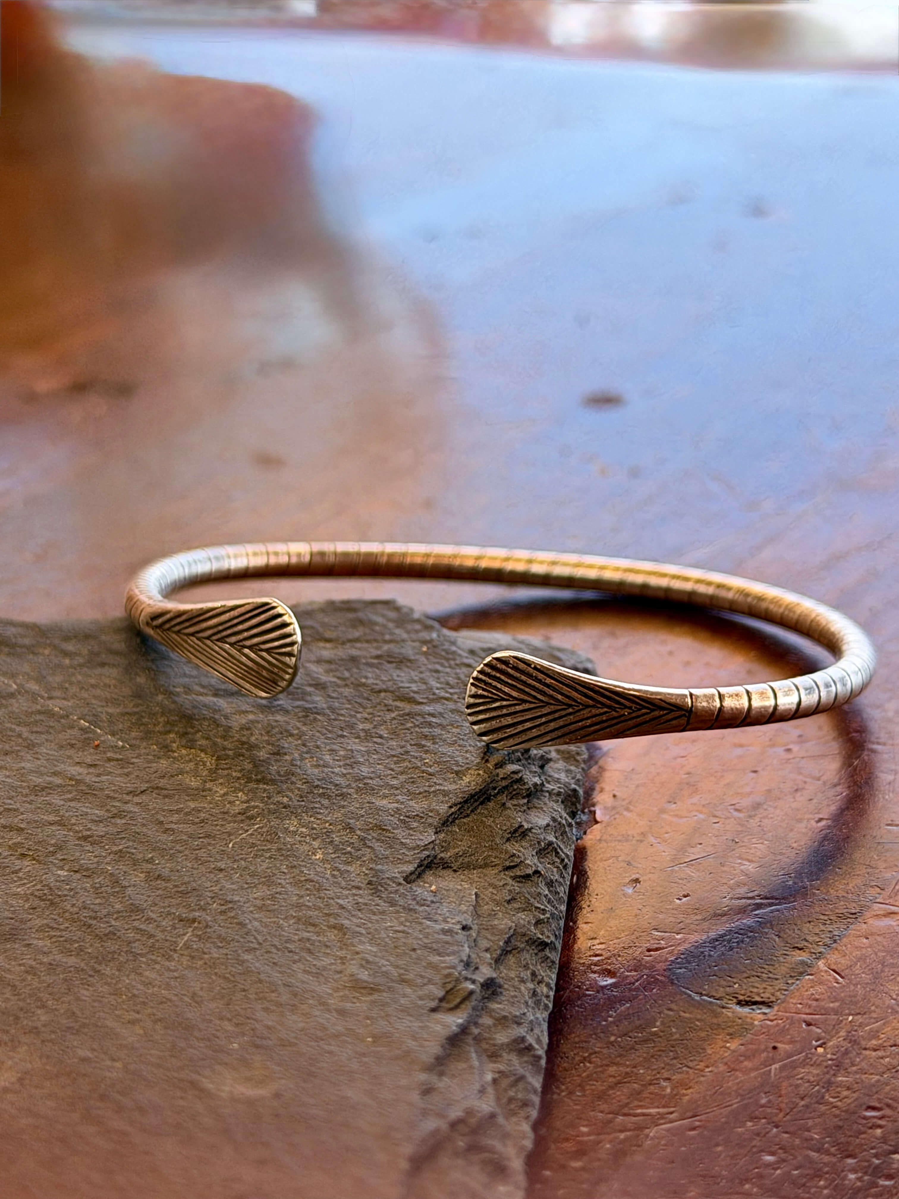 Bronze bracelet on a stone surface with a blurred background