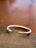 Silver bracelet with intricate designs on a stone surface