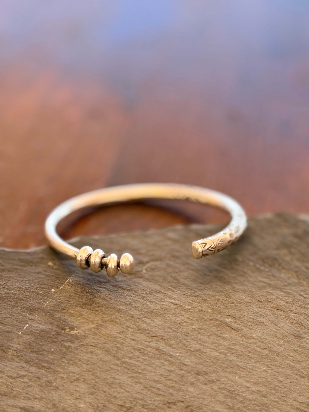 Gold bracelet with small beads on a wooden surface