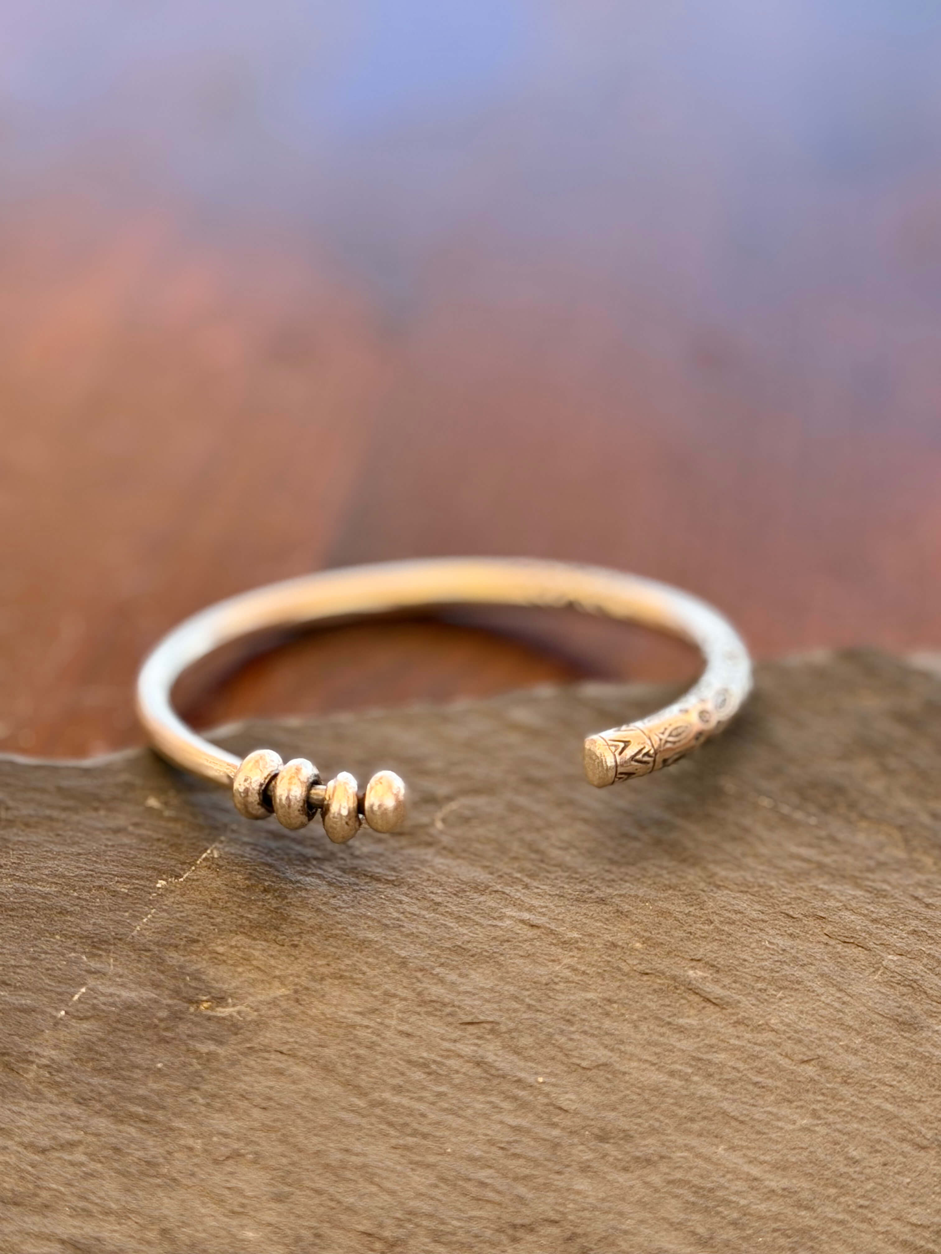 Gold bracelet with small beads on a wooden surface
