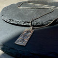 Necklace with a pendant on a dark stone surface