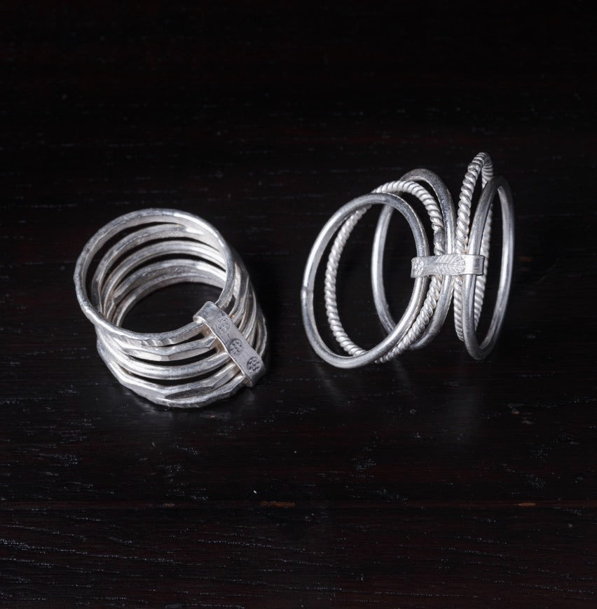 Two silver rings on a dark wooden surface