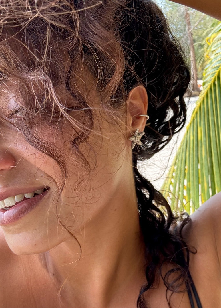 Close-up of a woman with wet hair outdoors, palm leaves visible