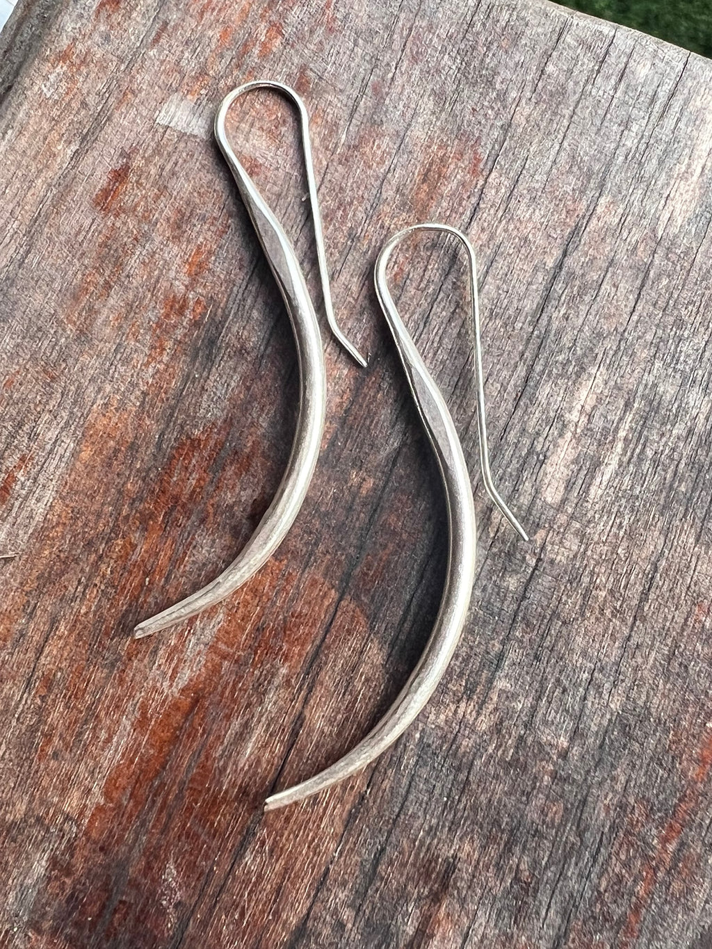 Silver earrings on a wooden surface
