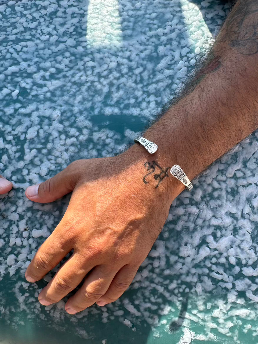 Hand with multiple bracelets on a textured surface