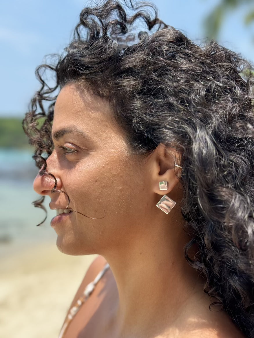 Woman with styled hair and earrings outdoors