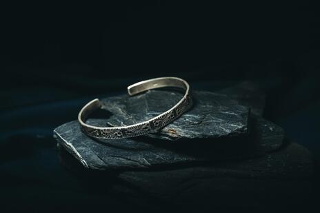 Silver bracelet on a dark stone surface