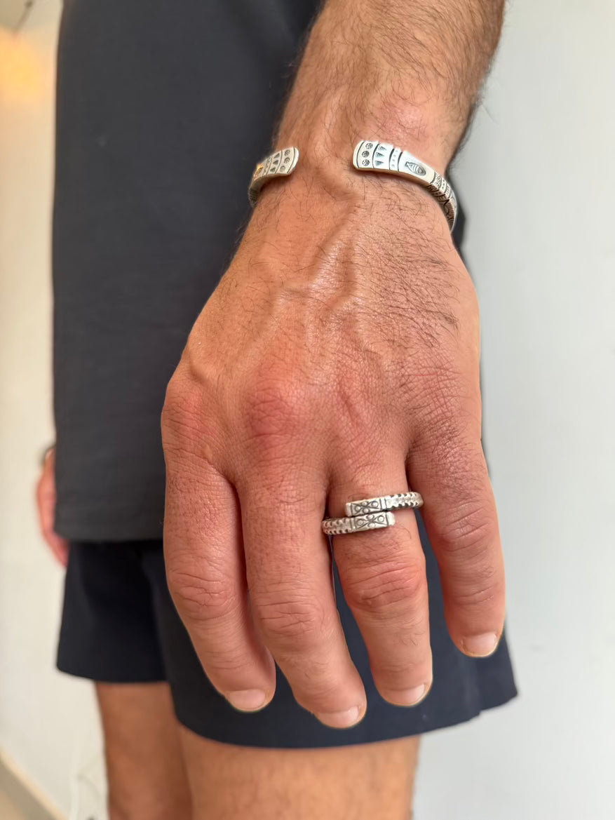 Hand wearing multiple silver rings with a blurred background