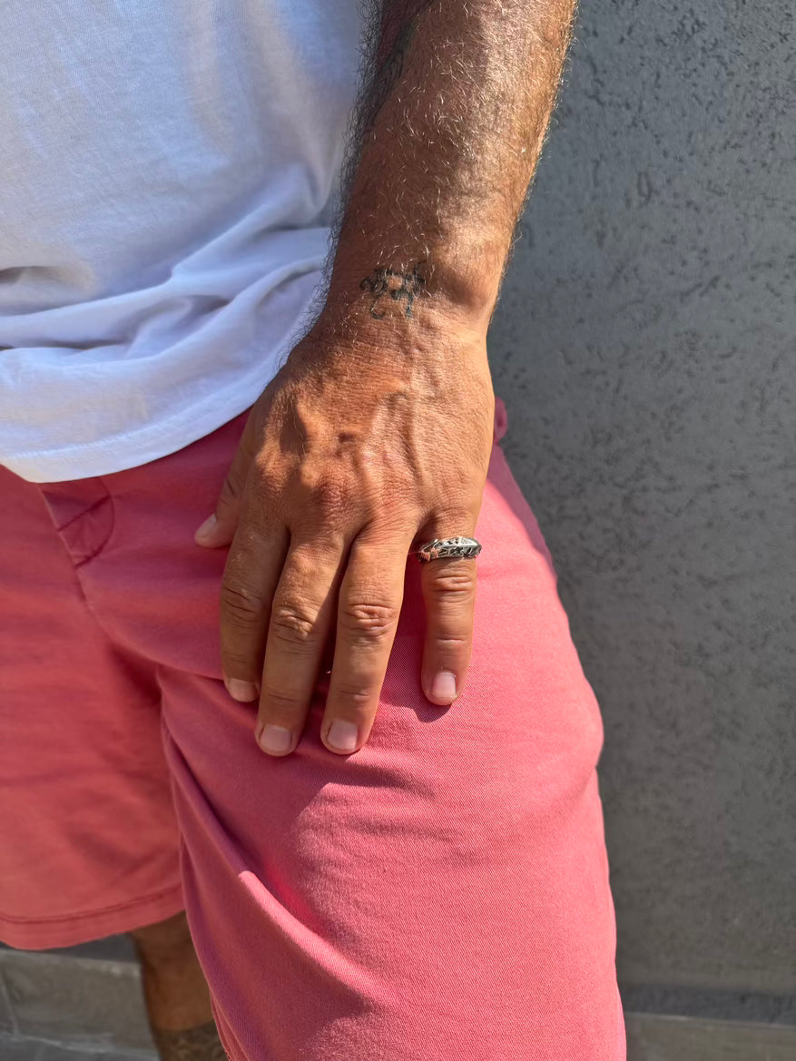 Person wearing a white shirt and pink shorts with a gray background