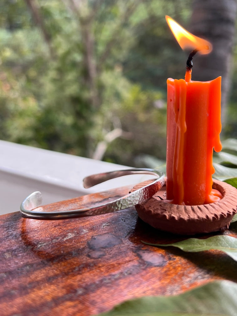Flint striker being used to ignite a fire with a blurred natural background