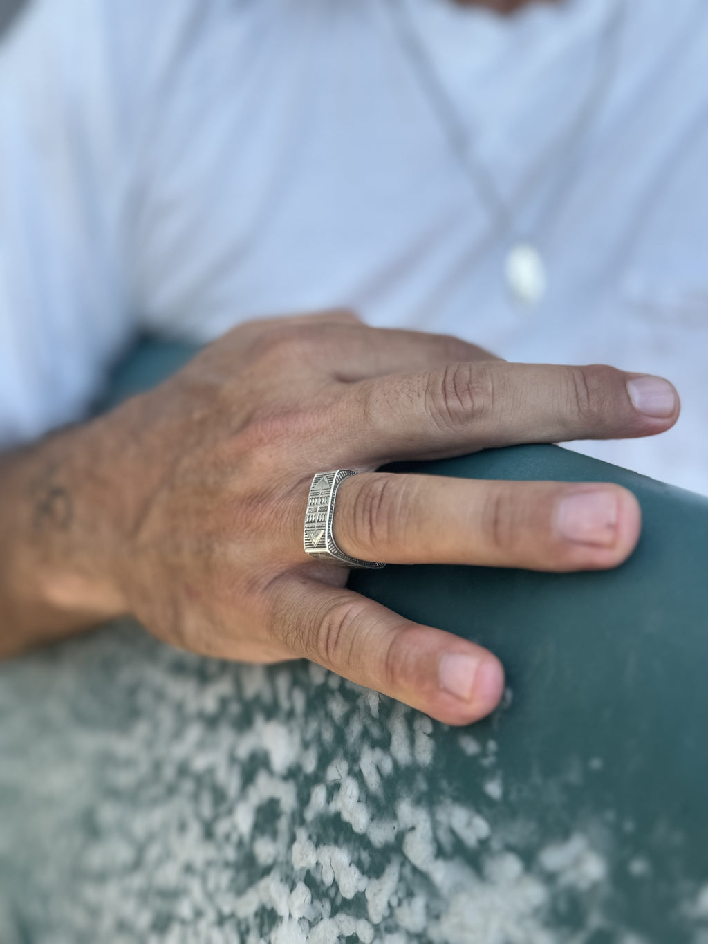 Hand wearing a ring on a blurred background